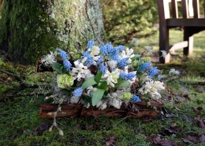 Liefdevol afscheidsbloemstukje met witte hyacinten en blauwe druifjes.