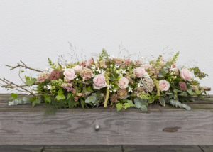 Sereen kistbloemstuk in zachte pasteltinten.