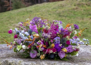 Uitbundig rondgestoken bontgekleurd voorjaars afscheidsbloemstukbloemstuk met Hyacinten, tulpen, rozen en mooie natuurlijke materialen.