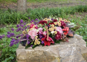 Rouwbloemstuk met bontgekleurde bloemen op basis van Callicarpa bessen.